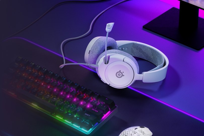 Arctis Nova 1 laying on the desk accompanied with glowing keyboard and aerox mouse.