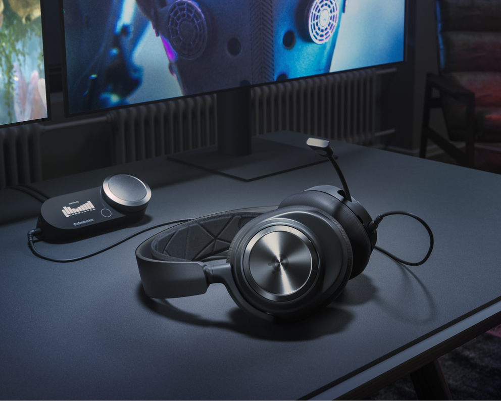 
 An Arctis Nova Pro and base station lie against a desktop setup.
 